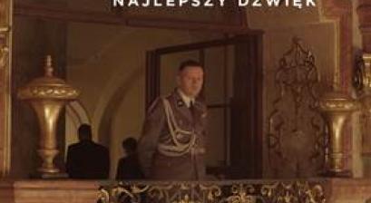 Plakat filmu STREFA INTERESÓW. Mężczyzna w niemieckim mundurze stojący na balkonie w pałacu