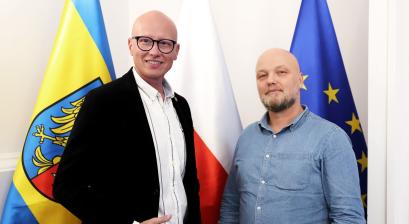 zdjęcie zastępcy burmistrza oraz pana Piotr Walendziuk na tle flagi Lublińca polski, oraz unii Europejskiej 