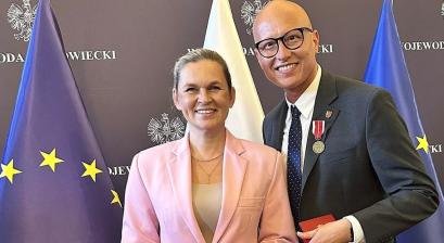 Minister edukacji Barbara Nowacka oraz zastępca burmistrza Gabriel Podbioł na tle flag 