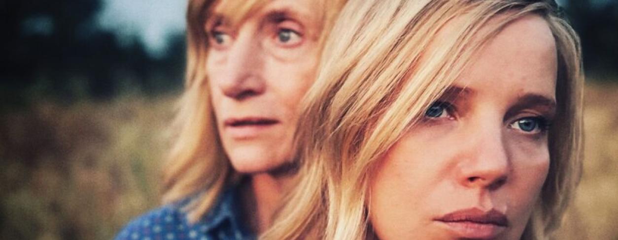 Plakat filmu KOBIETA Z…. Dwie kobiety o blond włosach stojące obok siebie w polu i patrzące przed siebie