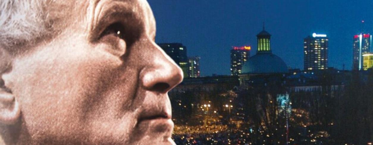 profil papieża Jana Pawła 2 na tle tłumu o zmroku z rozpalonymi świecami 