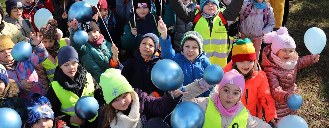 tłum dzieci w wieku przedszkolnym i szkolnym trzymających w rękach niebieskie balony na znak solidarności podczas happeningu z okazji Światowego Dnia Autyzmu