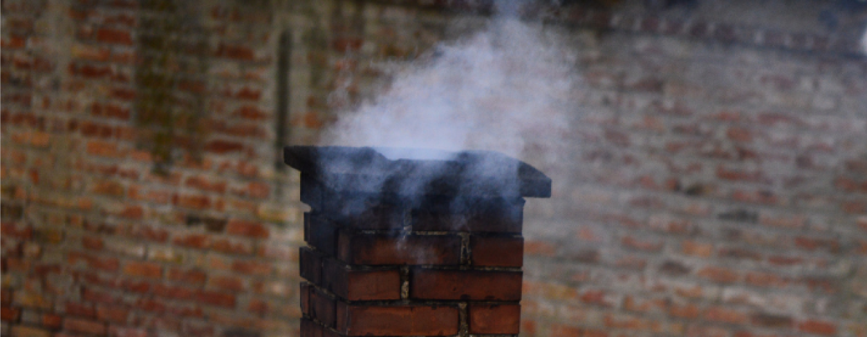 Osmolony, stary dymiący komin