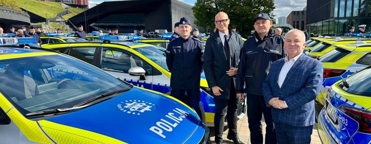 Komendant Policji w Katowicach nadinsp. Mariusza Krzystyniaka, wiceburmistrz Lublińca Gabriel Podbioł wśród nowych hybrydowych radiowozów przekazanych dla woj. śląskiego 
