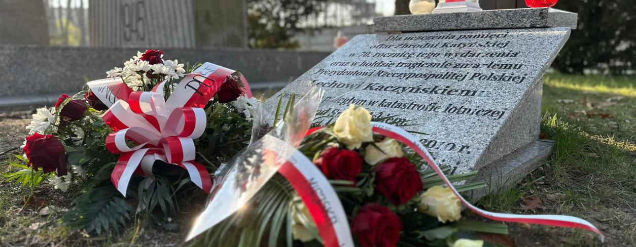 Wiązanki biało-czerwone pod tablicą upamiętniającą ofiary katastrofy smoleńskiej 